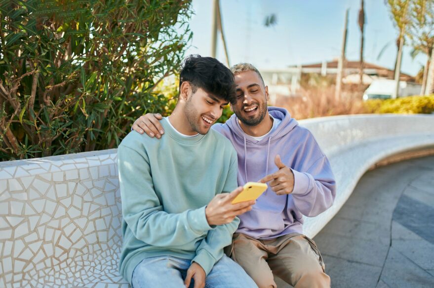 couple check phone while sat on bench